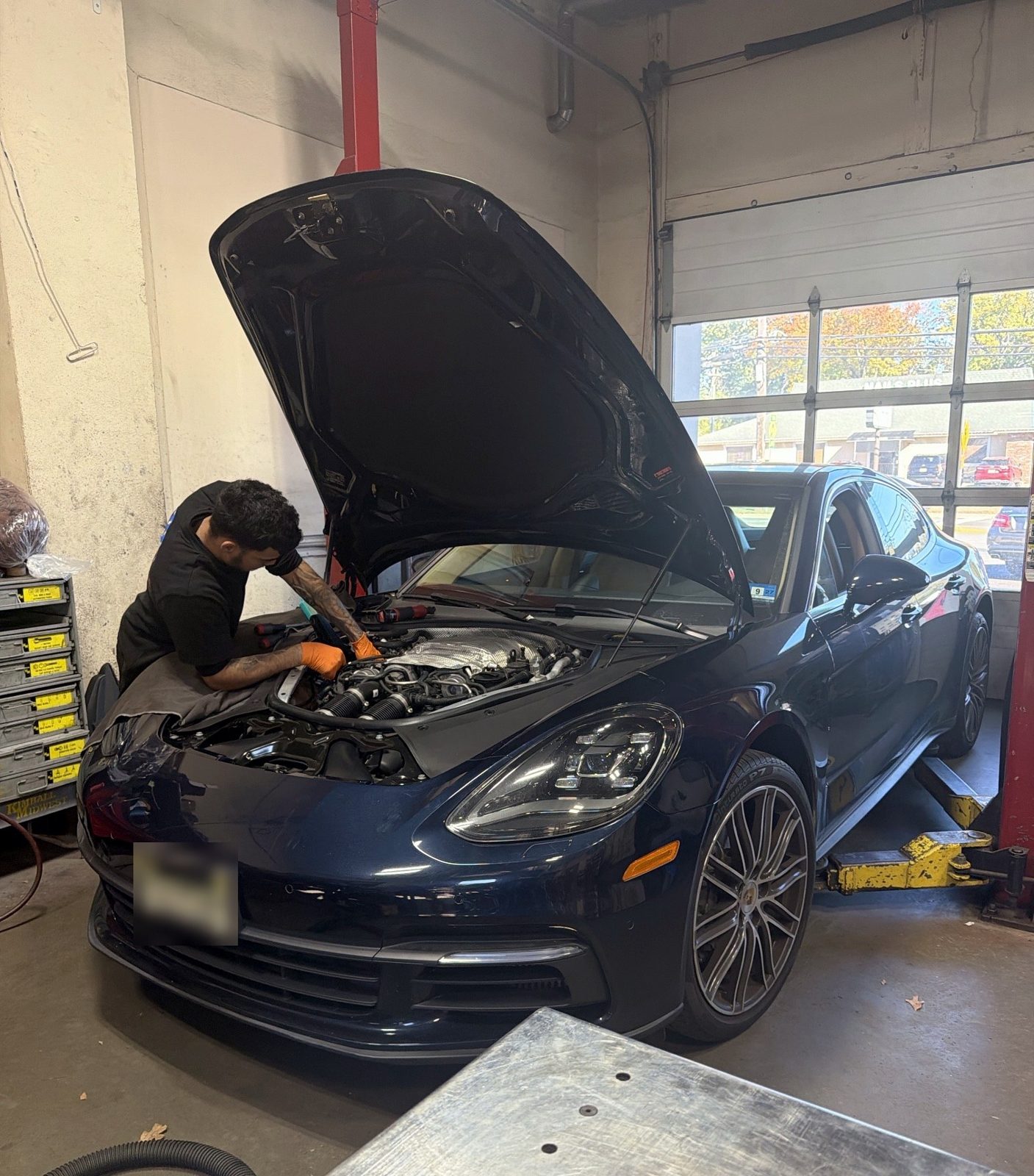 Massimo Motorworks technician working in the engine bay of a 2018 Porsche Panamera 4S in Shrewsbury NJ