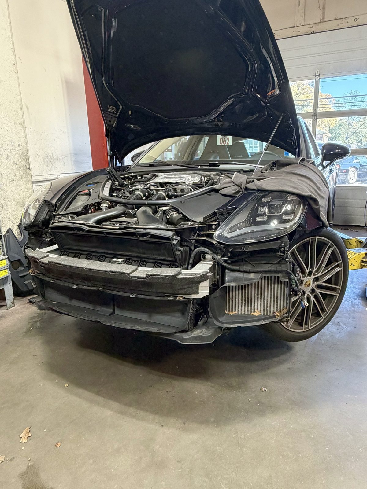 2018 Porsche Panamera 4S with the front bumper cover removed, leaves in the intercooler, at Massimo Motorworks in Shrewsbury NJ