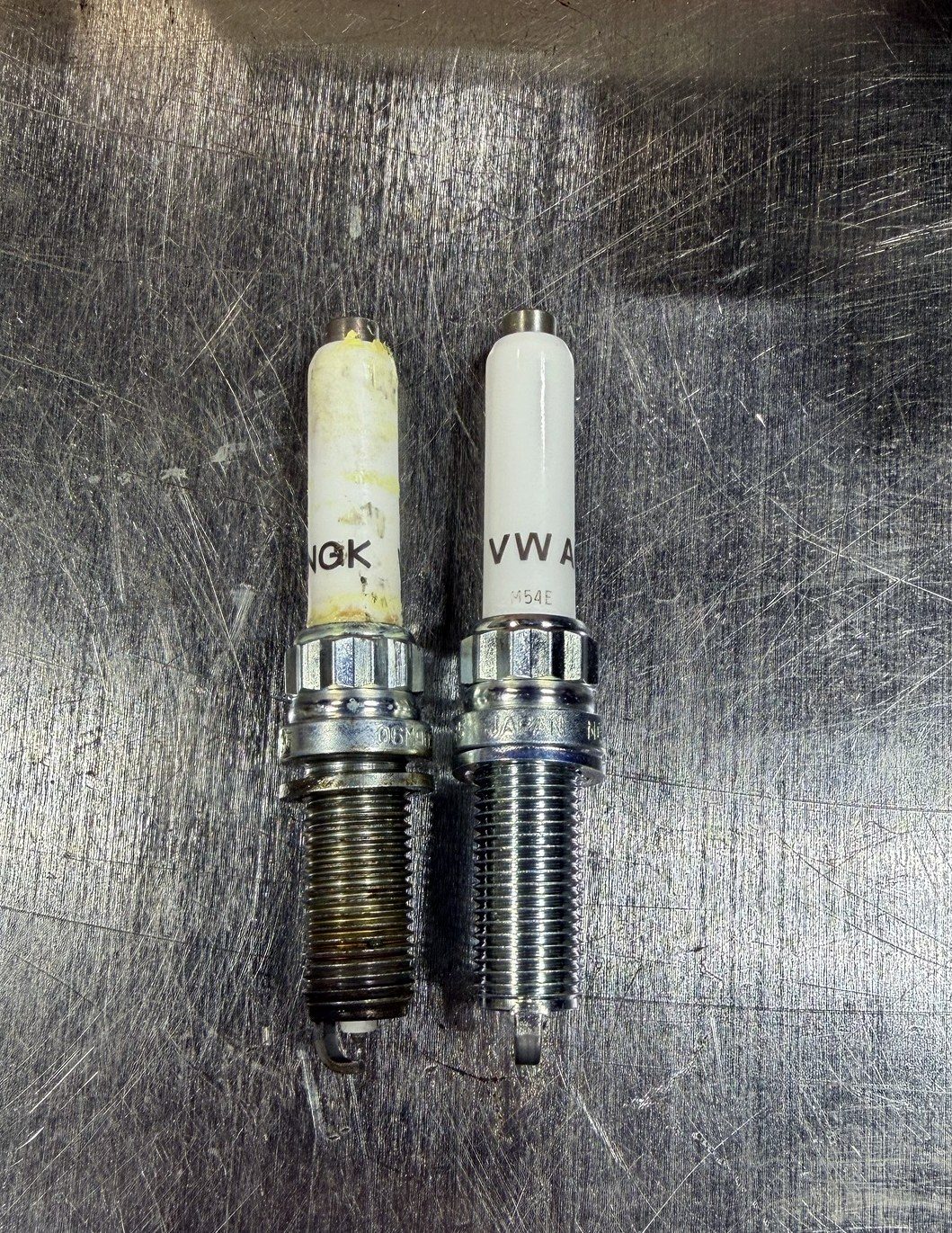 Old vs. new spark plug from a 2018 Porsche Panamera 4S 2.9L twin-turbo V6